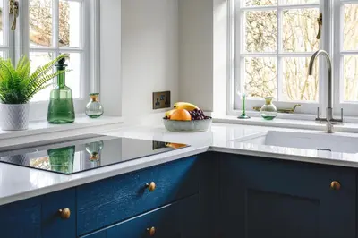 a kitchen with blue cabinets and a sink at Seascape Hideaways at Port Isaac in Port Isaac