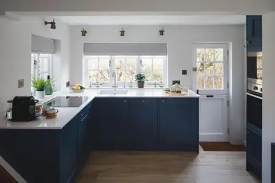 a kitchen with blue cabinets and white counters at Seascape Hideaways at Port Isaac in Port Isaac
