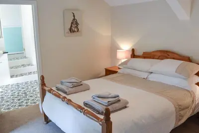 a bedroom with a bed with towels on it at Large Family House - sleeps 10. Central Location. 15 mins from coast. in Truro