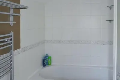 a bathroom with a white tub with a green bottle at Large Family House - sleeps 10. Central Location. 15 mins from coast. in Truro