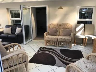 a living room with two chairs and a couch at Large Family House - sleeps 10. Central Location. 15 mins from coast. in Truro