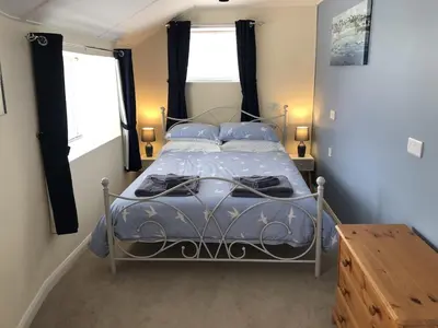 a bedroom with a bed with blue sheets and pillows at Large Family House - sleeps 10. Central Location. 15 mins from coast. in Truro