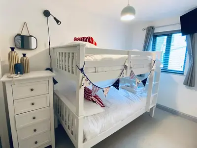 a white crib with a hammock in a bedroom at Tregenna House - St Ives, A Beautiful Newly Refurbished 4 Bedroom Family Town House With Alfresco Dining Garden and Private Parking Spaces in St Ives