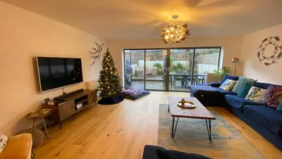 a living room with a christmas tree and a blue couch at Tregenna House - St Ives, A Beautiful Newly Refurbished 4 Bedroom Family Town House With Alfresco Dining Garden and Private Parking Spaces in St Ives