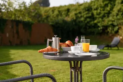 a table with a breakfast of croissants and orange juice at Trewhiddle 40 - A Luxury Cottage by Together Travel in St Austell
