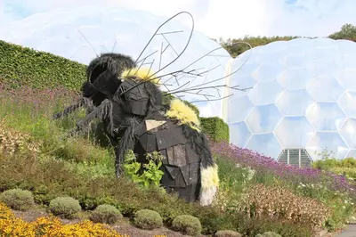 a statue of a man in a field of flowers at Trewhiddle 40 - A Luxury Cottage by Together Travel in St Austell
