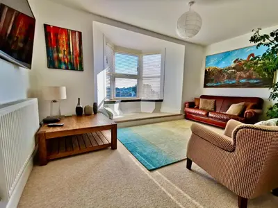 a living room with a couch and a table at Seashells at 2 TRENCROM COURT ST IVES in Carbis Bay