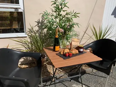 a table with a bottle of wine and food on it at Sandsifter at 4 Trencrom Court, Carbis Bay,St Ives, Cornwall in Carbis Bay