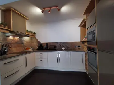 a kitchen with white cabinets and a sink and a microwave at Sandsifter at 4 Trencrom Court, Carbis Bay,St Ives, Cornwall in Carbis Bay