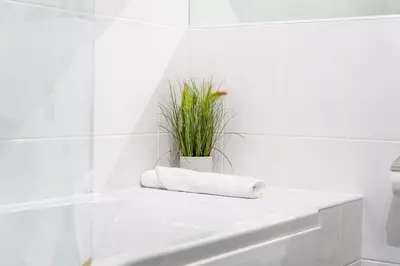 a white bathroom with a white tub and a plant at Trewhiddle Retreat V8 by Together Travel - Luxury 3-Bedroom Villa in St Austell