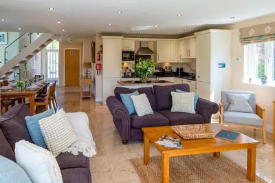a living room with two couches and a table at Trewhiddle Retreat V8 by Together Travel - Luxury 3-Bedroom Villa in St Austell