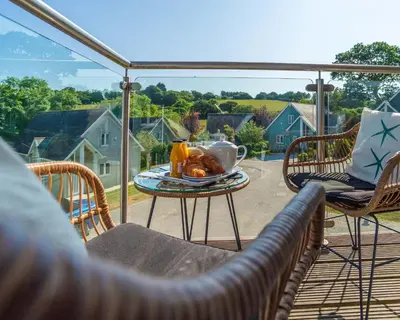 a table with a plate of food on a patio at Trewhiddle Retreat V4 by Together Travel - Luxury 4-Bedroom Villa in St Austell
