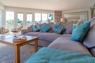a living room with a couch and a table at Trewhiddle Retreat V4 by Together Travel - Luxury 4-Bedroom Villa in St Austell