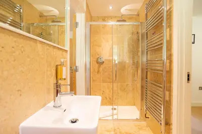 a bathroom with a sink and a shower at Trewhiddle Retreat V4 by Together Travel - Luxury 4-Bedroom Villa in St Austell