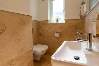 a bathroom with a white sink and a toilet at Trewhiddle Retreat V4 by Together Travel - Luxury 4-Bedroom Villa in St Austell