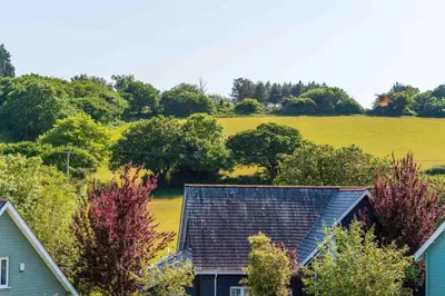 a roof of a house with a field in the background at Trewhiddle Retreat V4 by Together Travel - Luxury 4-Bedroom Villa in St Austell