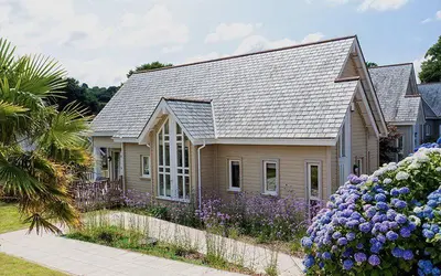 a small house with purple flowers in front of it at Trewhiddle Retreat V31 by Together Travel - Luxury 3-Bedroom Villa in St Austell