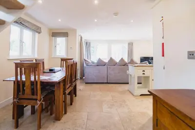 a kitchen with a table and chairs and a couch at Trewhiddle Retreat V31 by Together Travel - Luxury 3-Bedroom Villa in St Austell