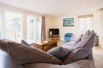 a living room with a couch and a table at Trewhiddle Retreat V31 by Together Travel - Luxury 3-Bedroom Villa in St Austell