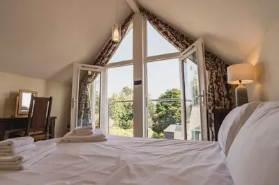a bedroom with a bed with a large window at Trewhiddle Retreat V31 by Together Travel - Luxury 3-Bedroom Villa in St Austell