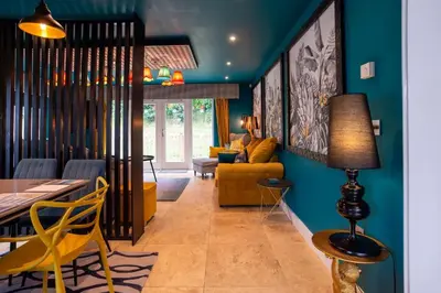 a living room with blue walls and a table and chairs at Trewhiddle Retreat V3 by Together Travel - Luxury 4-Bedroom Villa in St Austell