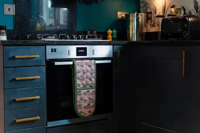 a kitchen with a stove with a towel on it at Trewhiddle Retreat V3 by Together Travel - Luxury 4-Bedroom Villa in St Austell