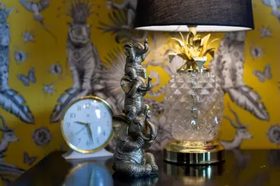 a table with a lamp and a clock on it at Trewhiddle Retreat V3 by Together Travel - Luxury 4-Bedroom Villa in St Austell