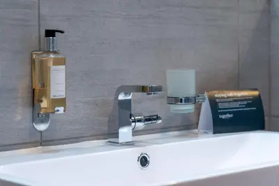 a sink with a soap dispenser and a bottle on it at Trewhiddle Retreat V3 by Together Travel - Luxury 4-Bedroom Villa in St Austell