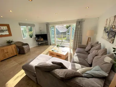 a living room with a couch and a table at Trewhiddle Retreat V29 by Together Travel - Luxury 4-Bedroom Villa in St Austell