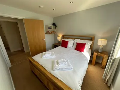 a bedroom with a bed with towels on it at Trewhiddle Retreat V29 by Together Travel - Luxury 4-Bedroom Villa in St Austell