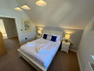 a bedroom with a bed with two towels on it at Trewhiddle Retreat V29 by Together Travel - Luxury 4-Bedroom Villa in St Austell