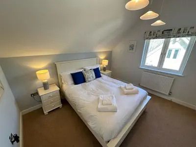 a bedroom with a bed with two pillows and a window at Trewhiddle Retreat V29 by Together Travel - Luxury 4-Bedroom Villa in St Austell