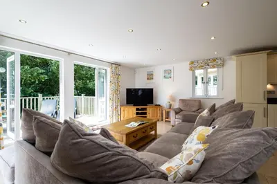 a living room with a couch and a tv at Trewhiddle Retreat V27 by Together Travel - Luxury 3-Bedroom Villa in St Austell