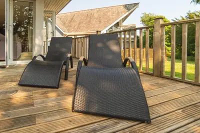 three black chairs sitting on a deck at Trewhiddle Retreat V25 by Together Travel - Luxury 4-Bedroom Villa in St Austell