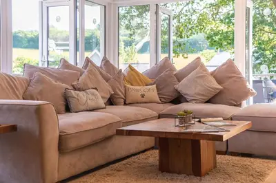 a living room with a couch with pillows on it at Trewhiddle Retreat V25 by Together Travel - Luxury 4-Bedroom Villa in St Austell