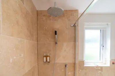 a bathroom with a shower with a glass door at Trewhiddle Retreat V25 by Together Travel - Luxury 4-Bedroom Villa in St Austell