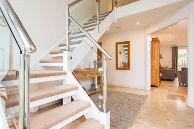 a spiral staircase in a house with a living room at Trewhiddle Retreat V24 by Together Travel - Luxury 4-Bedroom Villa in St Austell