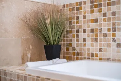 a bathroom with a white tub and a potted plant at Trewhiddle Retreat V24 by Together Travel - Luxury 4-Bedroom Villa in St Austell