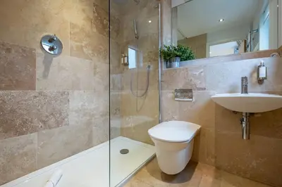 a bathroom with a shower and a toilet and a sink at Trewhiddle Retreat V24 by Together Travel - Luxury 4-Bedroom Villa in St Austell