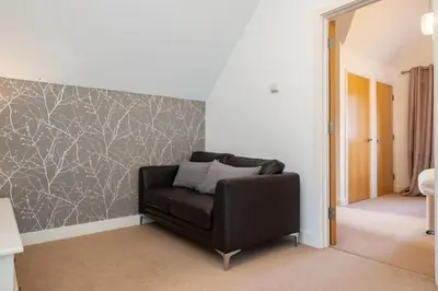a black leather chair in a room with a wall at Trewhiddle Retreat V24 by Together Travel - Luxury 4-Bedroom Villa in St Austell