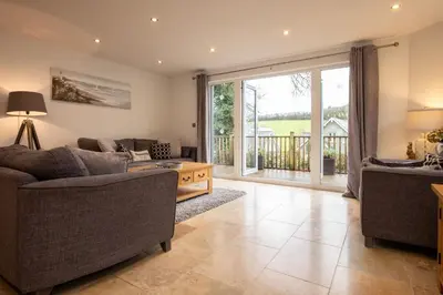 a living room with a couch and a table at Trewhiddle Retreat V24 by Together Travel - Luxury 4-Bedroom Villa in St Austell