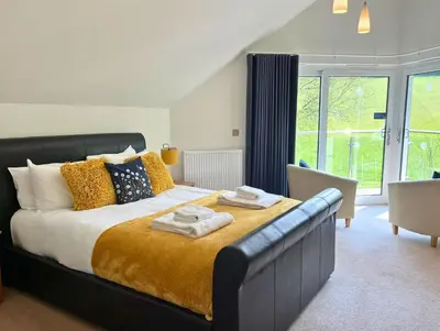 a bedroom with a large bed with towels on it at Trewhiddle Retreat V23 by Together Travel - Luxury 4-Bedroom Villa in St Austell