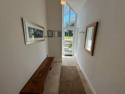 a hallway with a wooden bench and a window at Trewhiddle Retreat V23 by Together Travel - Luxury 4-Bedroom Villa in St Austell