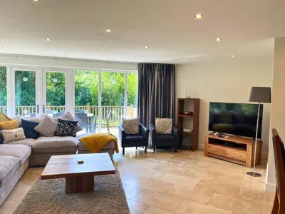 a living room with a couch and a flat screen tv at Trewhiddle Retreat V23 by Together Travel - Luxury 4-Bedroom Villa in St Austell