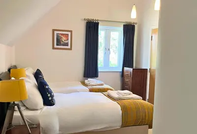 a bedroom with two beds and a window at Trewhiddle Retreat V23 by Together Travel - Luxury 4-Bedroom Villa in St Austell