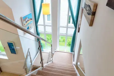 a staircase in a house with a window at Trewhiddle Retreat V21 by Together Travel - Luxury 3-Bedroom Villa in St Austell