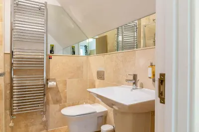 a bathroom with a sink and a toilet and a mirror at Trewhiddle Retreat V21 by Together Travel - Luxury 3-Bedroom Villa in St Austell