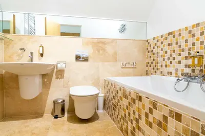 a bathroom with a sink and a tub and a toilet at Trewhiddle Retreat V21 by Together Travel - Luxury 3-Bedroom Villa in St Austell