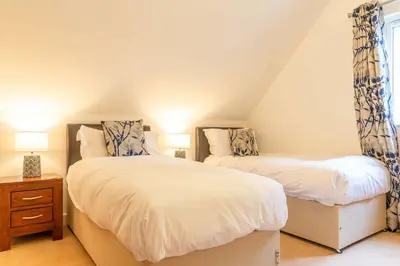 a bedroom with two beds and a window at Trewhiddle Retreat V21 by Together Travel - Luxury 3-Bedroom Villa in St Austell