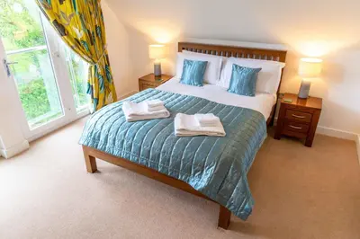 a bedroom with a large bed with two towels on it at Trewhiddle Retreat V21 by Together Travel - Luxury 3-Bedroom Villa in St Austell